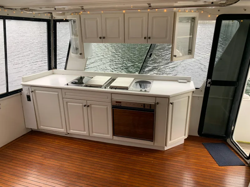 Slide: The Image of 1991 TransWorld Cockpit Motoryacht interior with white cabinetry and wooden flooring. - 27