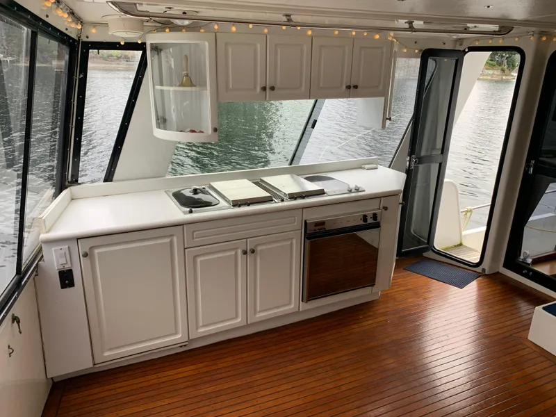 Slide: The Image of 1991 TransWorld Cockpit Motoryacht interior with kitchen, white cabinets, and wood flooring. - 26