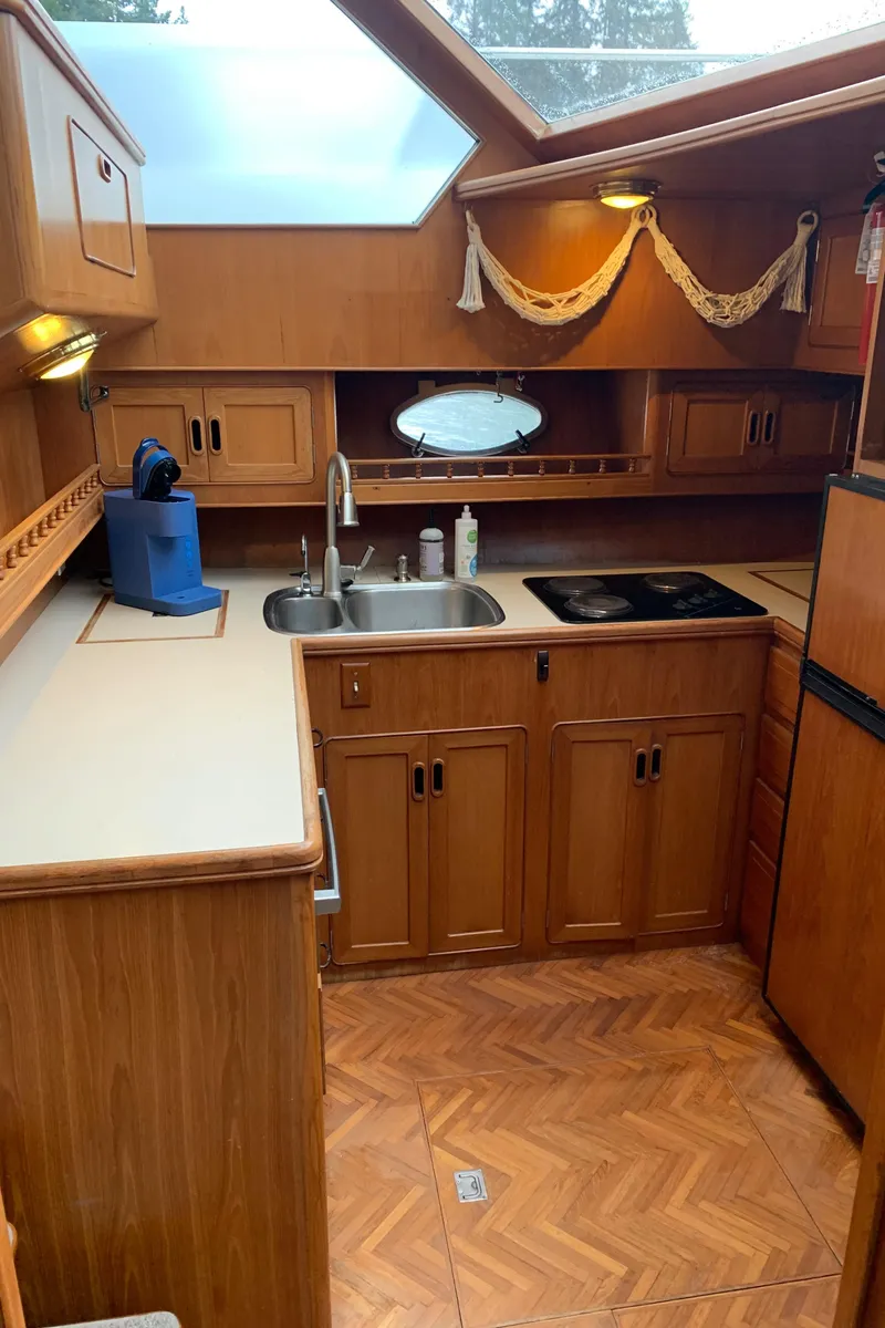 Slide: The Image of 1991 TransWorld Cockpit Motoryacht kitchen with wooden cabinetry and modern appliances. - 32