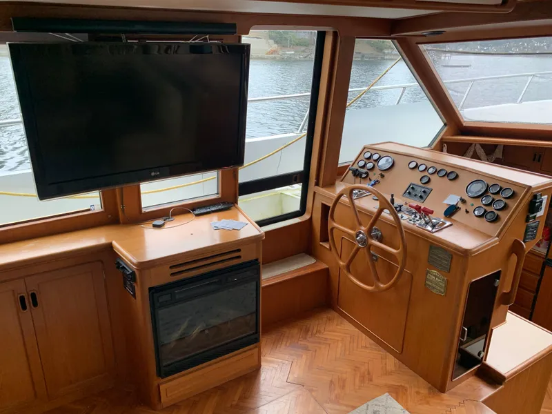 Slide: The Image of 1991 TransWorld Cockpit Motoryacht helm with steering wheel, control panel, and mounted TV. - 17