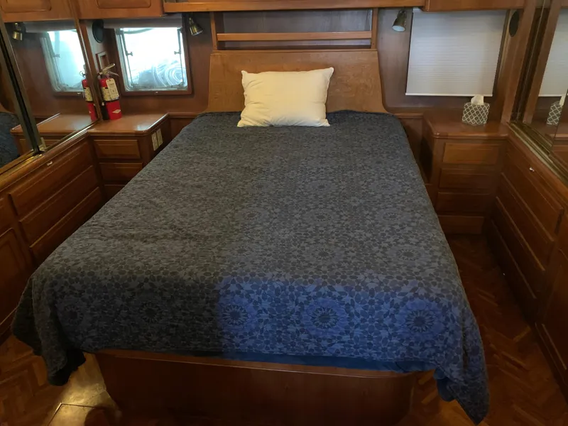 Slide: The Image of Cozy bedroom in 1991 TransWorld Cockpit Motoryacht with blue bedspread and wooden cabinetry. - 15