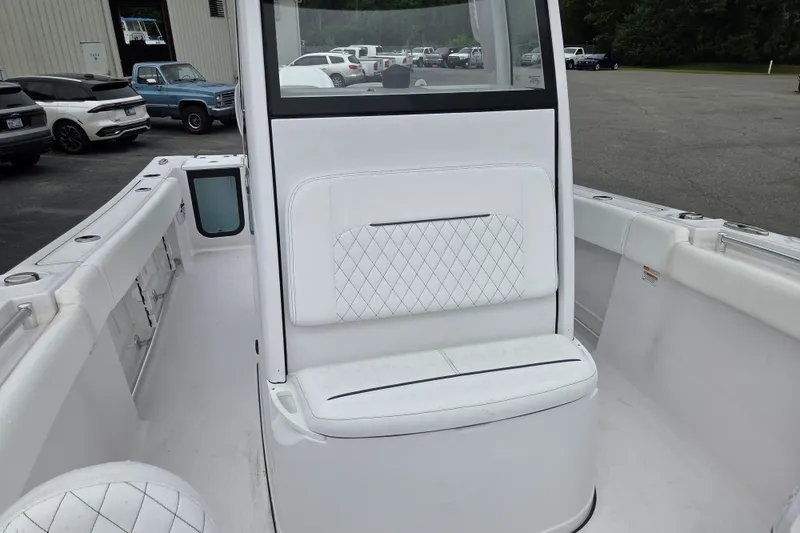 Slide: The Image of 2026 Sportsman Open 232 Center Console boat interior with white seating and storage compartments. - 8