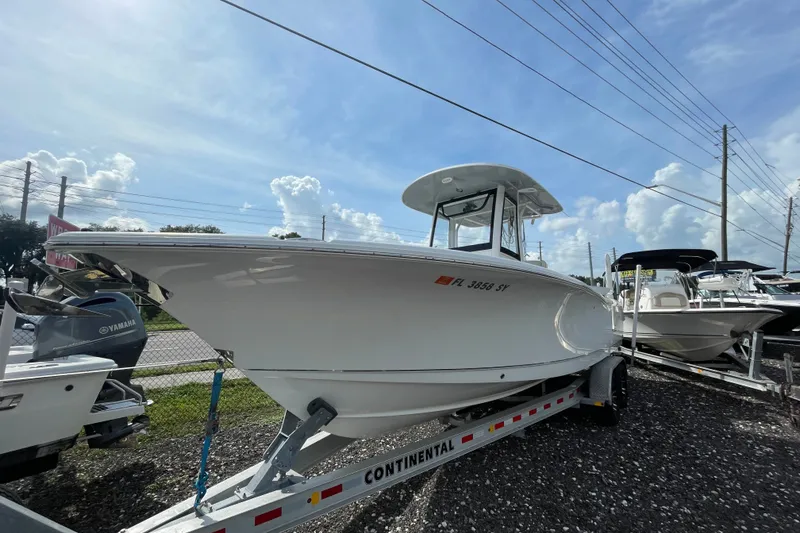 The Image of 2021 Sea Hunt Ultra 265SE boat on trailer, displayed outdoors under a clear sky. - 0