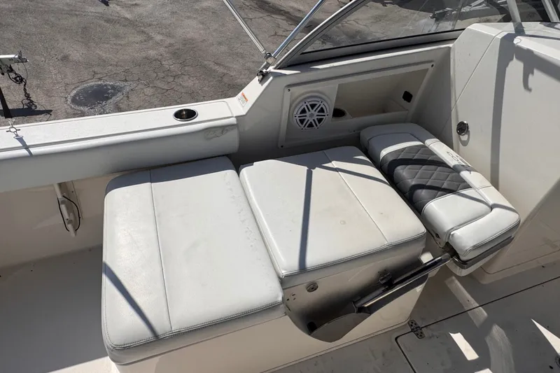 Slide: The Image of 2023 Cobia 220 Dual Console boat interior with cushioned seating and speaker. - 6