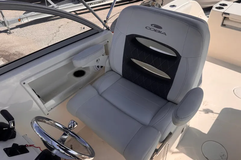 Slide: The Image of Captain's seat on 2023 Cobia 220 Dual Console boat, featuring sleek design and comfortable upholstery. - 11