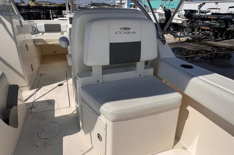 Slide: The Image of 2023 Cobia 220 Dual Console boat interior with cushioned seating and storage. - 14