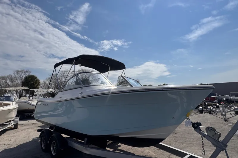 Slide: The Image of 2023 Cobia 220 Dual Console boat on trailer under blue sky. - 3