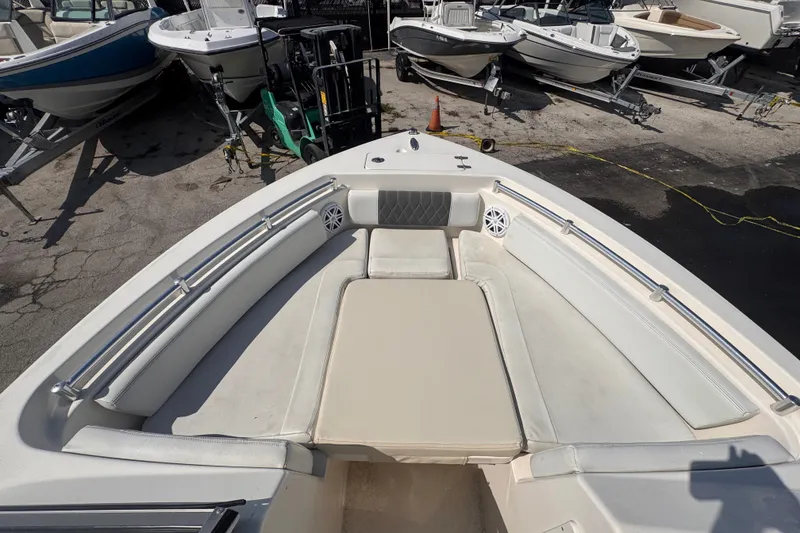 Slide: The Image of 2023 Cobia 220 Dual Console boat interior with cushioned seating and stainless steel rails. - 16