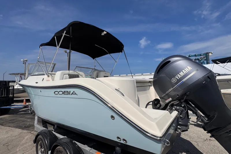 Slide: The Image of 2023 Cobia 220 Dual Console boat with Yamaha engine on trailer under blue sky. - 4