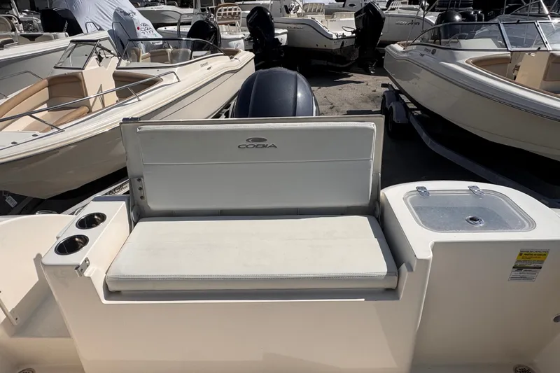 Slide: The Image of 2023 Cobia 220 Dual Console boat interior with seating and cup holders. - 13