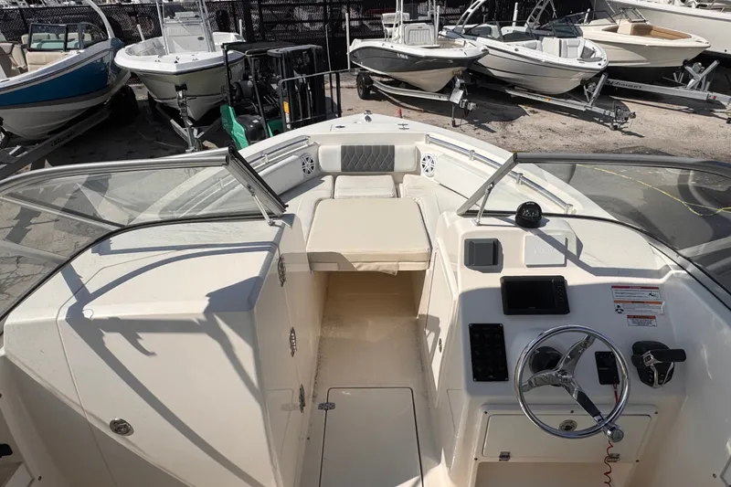 Slide: The Image of 2023 Cobia 220 Dual Console boat interior with steering wheel and seating area. - 8