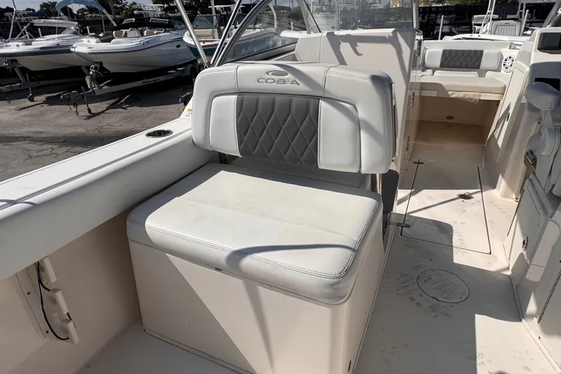 Slide: The Image of 2023 Cobia 220 Dual Console boat interior with cushioned seating and storage. - 7
