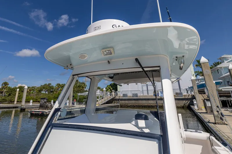 Slide: The Image of 2011 Everglades 295 Center Console boat docked at marina under clear blue sky. - 45