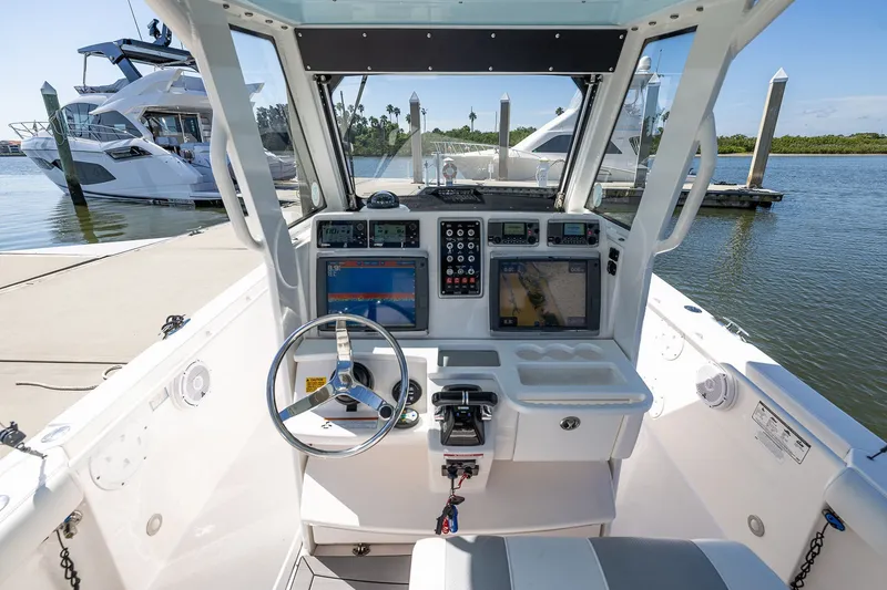 Slide: The Image of 2011 Everglades 295 Center Console boat cockpit with navigation screens and steering wheel. - 19