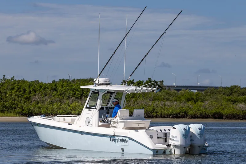 Slide: The Image of 2011 Everglades 295 Center Console boat on water with fishing rods and dual engines. - 16