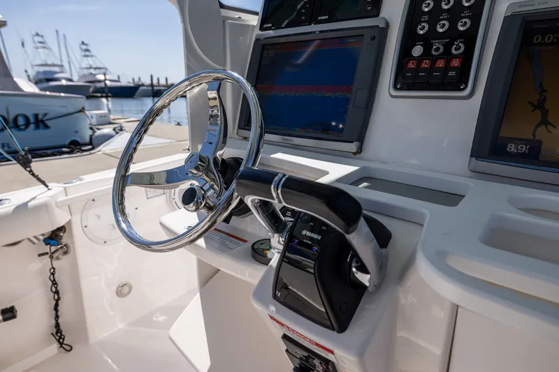Slide: The Image of 2011 Everglades 295 Center Console boat helm with steering wheel and navigation displays. - 29