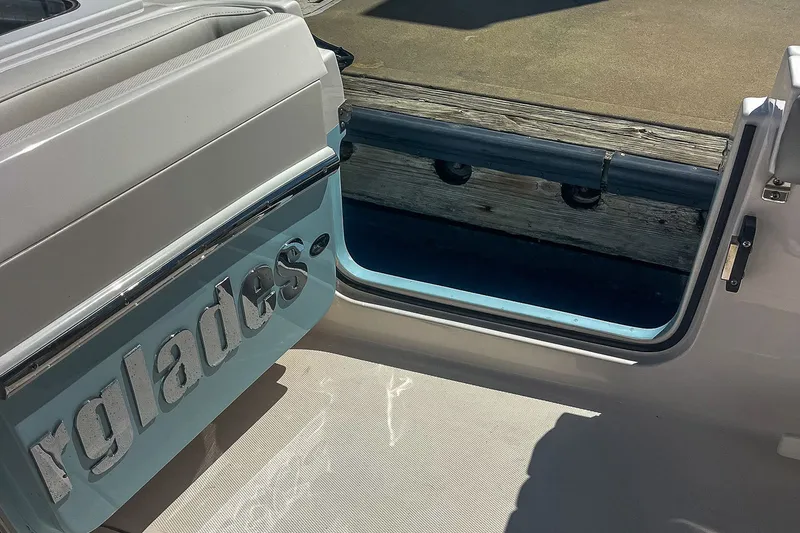 Slide: The Image of 2011 Everglades 295 Center Console boat with open side door and visible dock. - 25