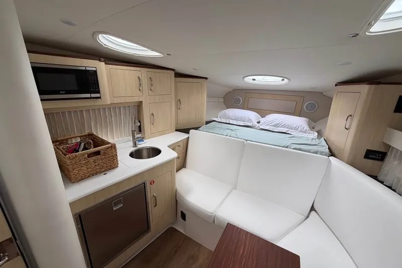 Slide: The Image of Interior of 2025 Regal 33 Express yacht with kitchenette, seating, and bed. - 11