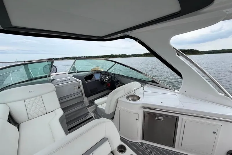 Slide: The Image of 2025 Regal 33 Express yacht interior with luxurious seating and modern helm on open water. - 2