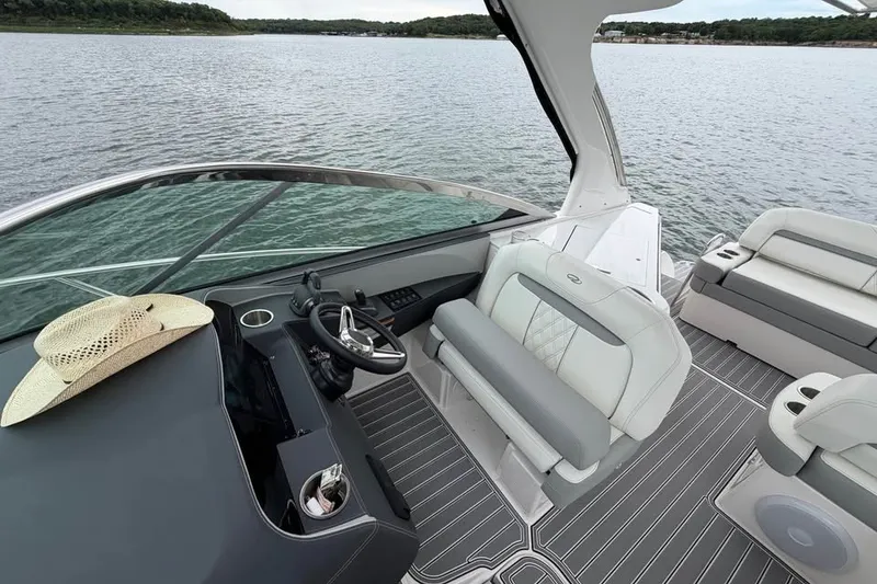Slide: The Image of 2025 Regal 33 Express boat interior with helm, seating, and a hat on the dashboard. - 5