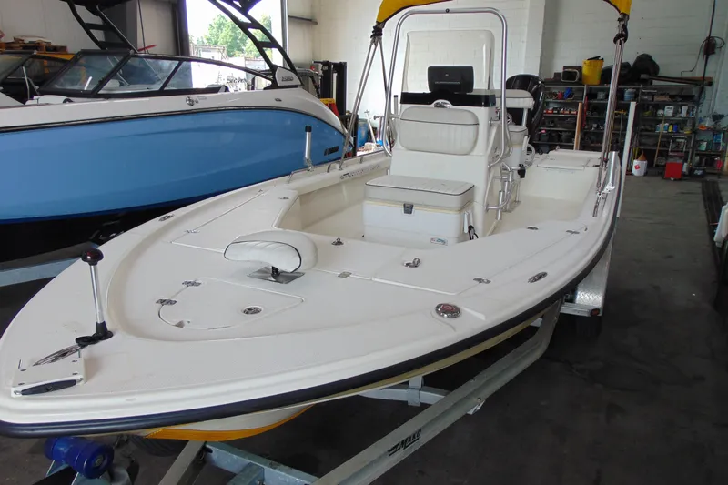 Slide: The Image of 2015 Mako 21 LTS boat in garage, white hull, on trailer. - 4