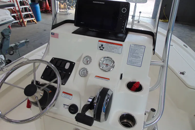 Slide: The Image of 2015 Mako 21 LTS boat console with steering wheel, gauges, and electronics. - 10