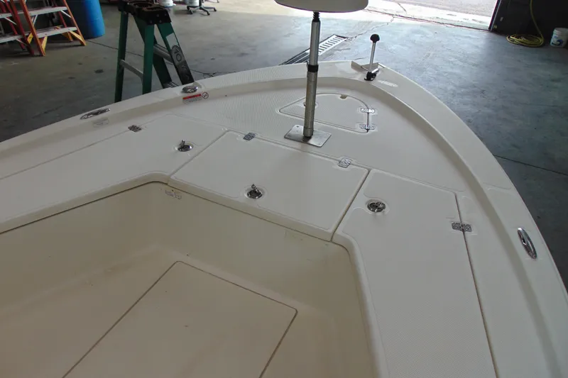 Slide: The Image of 2015 Mako 21 LTS boat deck with storage compartments in a garage setting. - 7