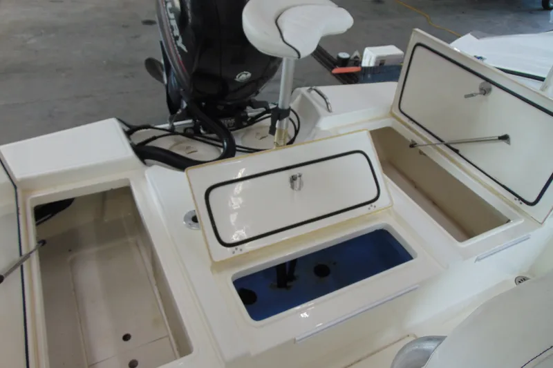 Slide: The Image of 2015 Mako 21 LTS boat interior with storage compartments and seating. - 9