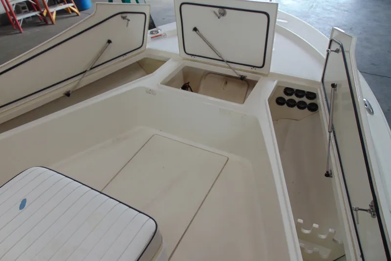 Slide: The Image of 2015 Mako 21 LTS boat interior with open storage compartments and seating. - 6