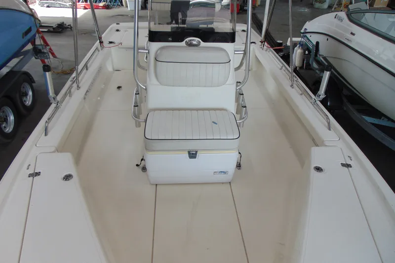 Slide: The Image of 2015 Mako 21 LTS boat interior with seating and storage, in a showroom setting. - 5