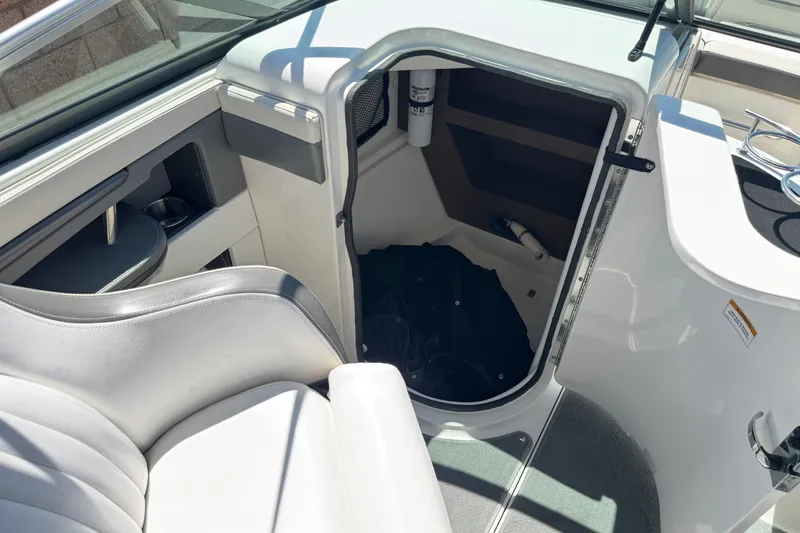 Slide: The Image of Interior view of a 2013 Sea Ray 220 Sundeck boat, featuring seating and storage compartment. - 26