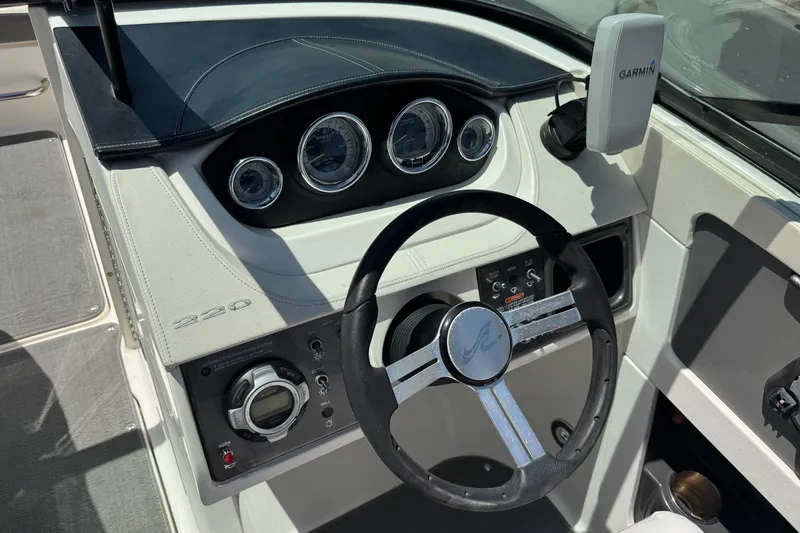Slide: The Image of Steering wheel and dashboard of 2013 Sea Ray 220 Sundeck boat with Garmin device. - 31