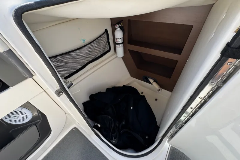 Slide: The Image of Interior storage compartment of a 2013 Sea Ray 220 Sundeck boat with fire extinguisher. - 27