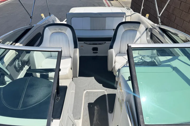 Slide: The Image of 2013 Sea Ray 220 Sundeck interior with white seating and glass windshield. - 16