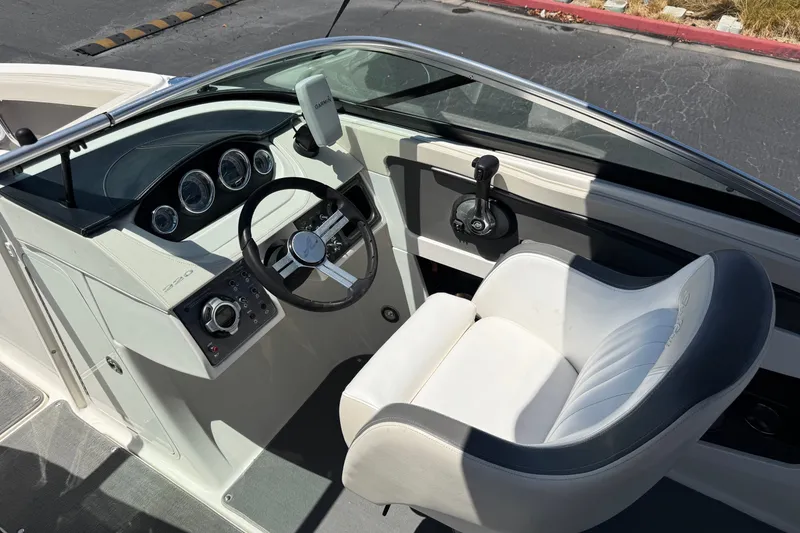 Slide: The Image of 2013 Sea Ray 220 Sundeck cockpit with steering wheel and control panel. - 29