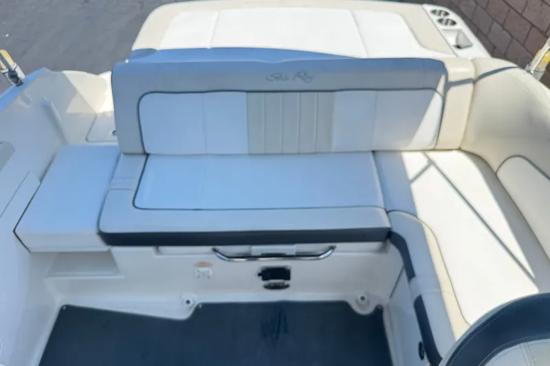 Slide: The Image of 2013 Sea Ray 220 Sundeck boat interior with white cushioned seating. - 17