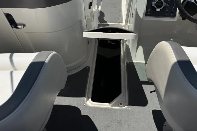 Slide: The Image of Interior view of a 2013 Sea Ray 220 Sundeck boat, featuring seating and storage compartment. - 28