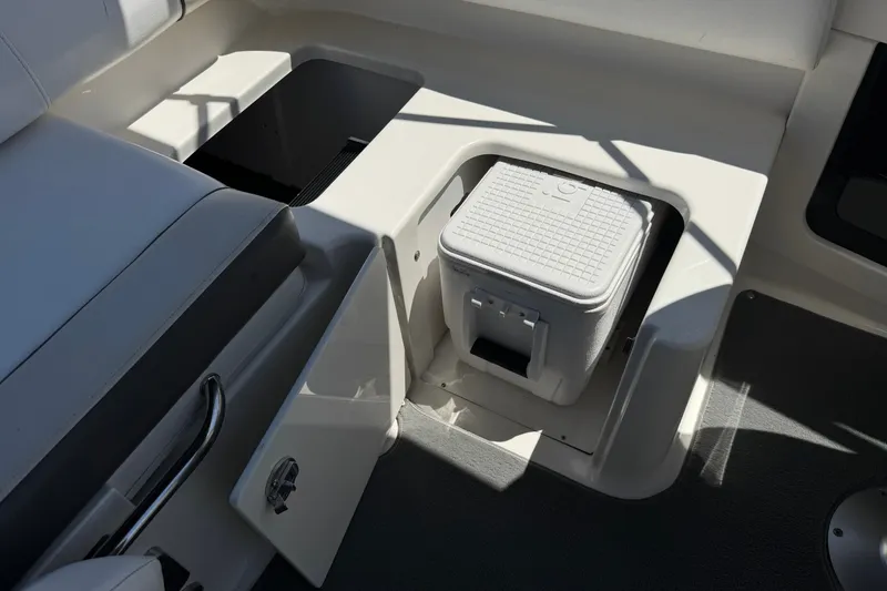 Slide: The Image of 2013 Sea Ray 220 Sundeck interior with storage compartment and cooler. - 24