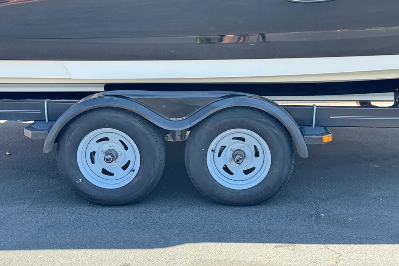 Slide: The Image of Trailer wheels of a 2013 Sea Ray 220 Sundeck boat on pavement. - 35