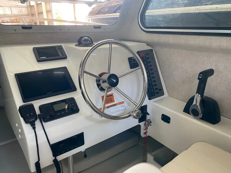 Slide: The Image of The image shows the helm of a 2022 Parker 2120 Sport Cabin boat with modern electronics. - 2