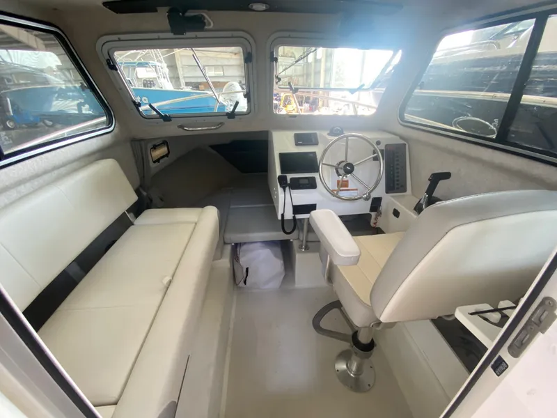 Slide: The Image of Interior of the 2022 Parker 2120 Sport Cabin with bench seating, helm, and windows. - 4