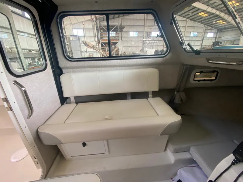 Slide: The Image of Interior of a 2022 Parker 2120 Sport Cabin with a white bench seat and large windows. - 8