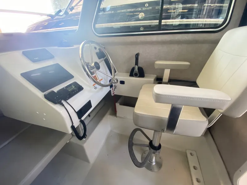 Slide: The Image of Interior of the 2022 Parker 2120 Sport Cabin with helm and white seat. - 3