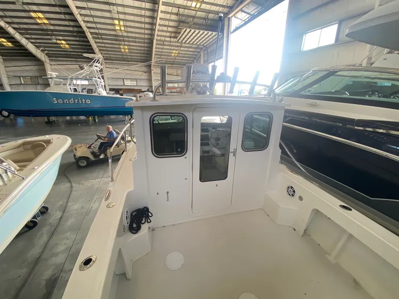 Slide: The Image of Parker 2120 Sport Cabin from 2022 in a warehouse, with closed cabin door and surrounding boats. - 10