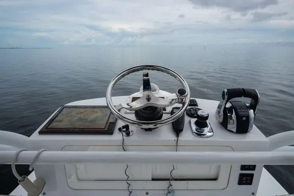 Slide: The Image of Helm of 2016 SeaHunter 45 Tournament boat with steering wheel and controls on calm water. - 16