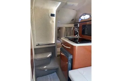 Slide: The Image of Interior of 2004 Sea Ray 240 Sundancer boat with kitchenette and seating area. - 12