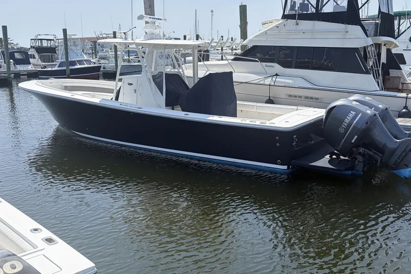 The Image of 2015 Regulator 34 Center Console boat docked in a marina with Yamaha engines. - 0