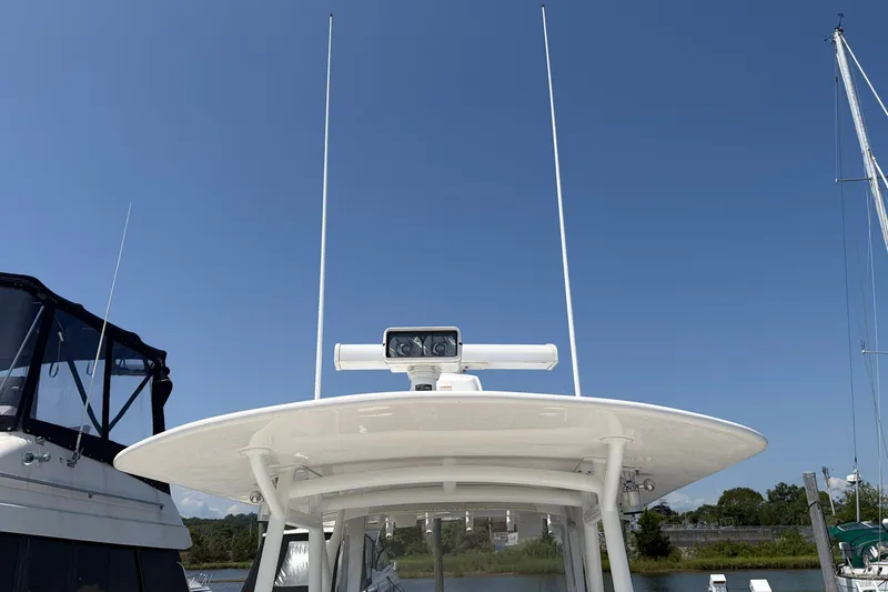 Slide: The Image of 2015 Regulator 34 Center Console boat with radar, docked under clear blue sky. - 11