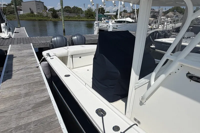Slide: The Image of 2015 Regulator 34 Center Console boat docked at marina, featuring twin engines. - 1