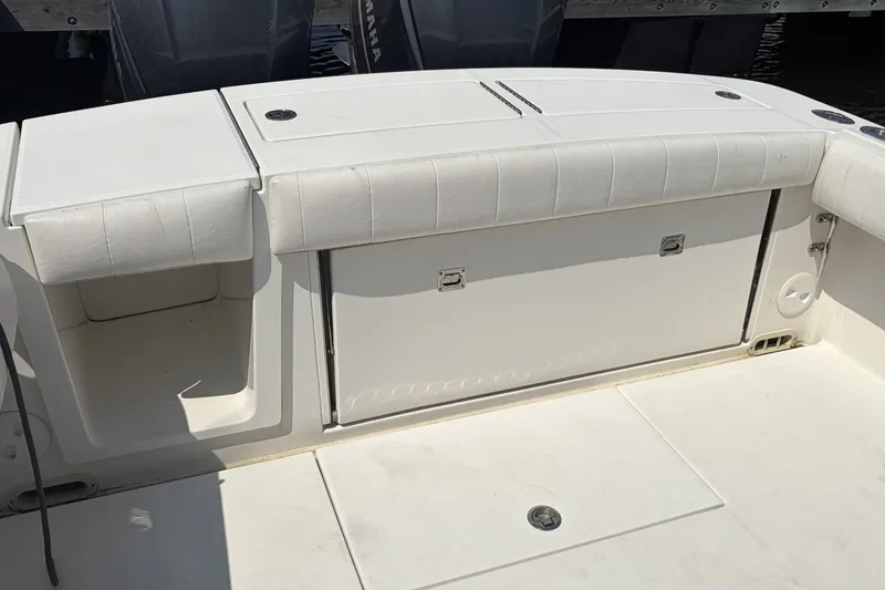 Slide: The Image of 2015 Regulator 34 Center Console boat interior with white cushioned seating and storage compartments. - 6